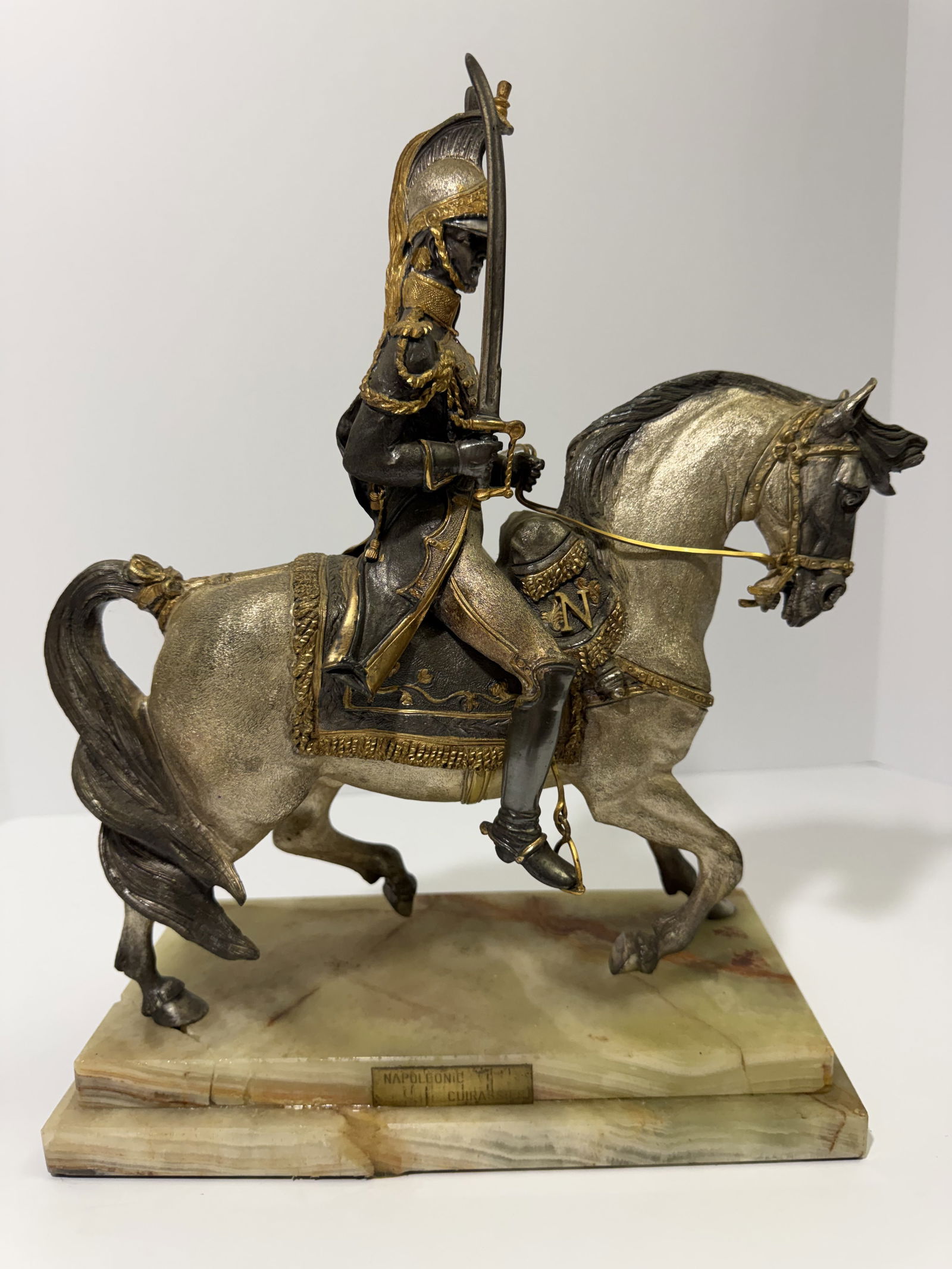 Antique French Napoleonic Cuirassier Bronze Equestrian Sculpture on Marble Base: An exceptionally detailed French Napoleonic Cuirassier equestrian bronze, depicting a mounted heavy cavalry officer of Napoleon's imperial Guard, rendered in dramatic forward motion. The figure wears
