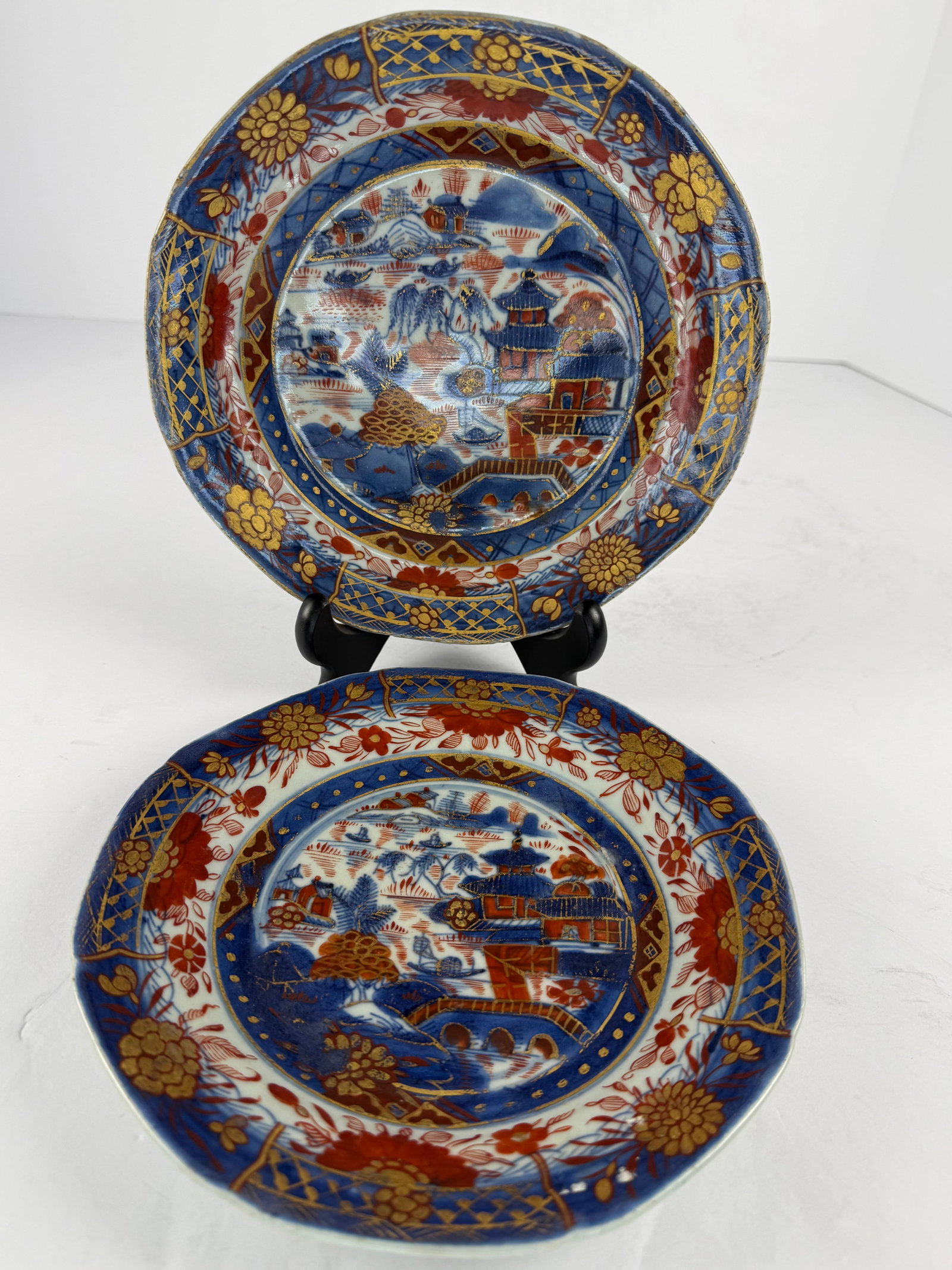Pair of Antique Japanese Imari Porcelain Plates: A beautiful matched pair of antique Japanese Imari porcelain plates, richly decorated in the traditional underglaze cobalt blue, iron red, and gilt palette. Each plate features a finely detailed sceni