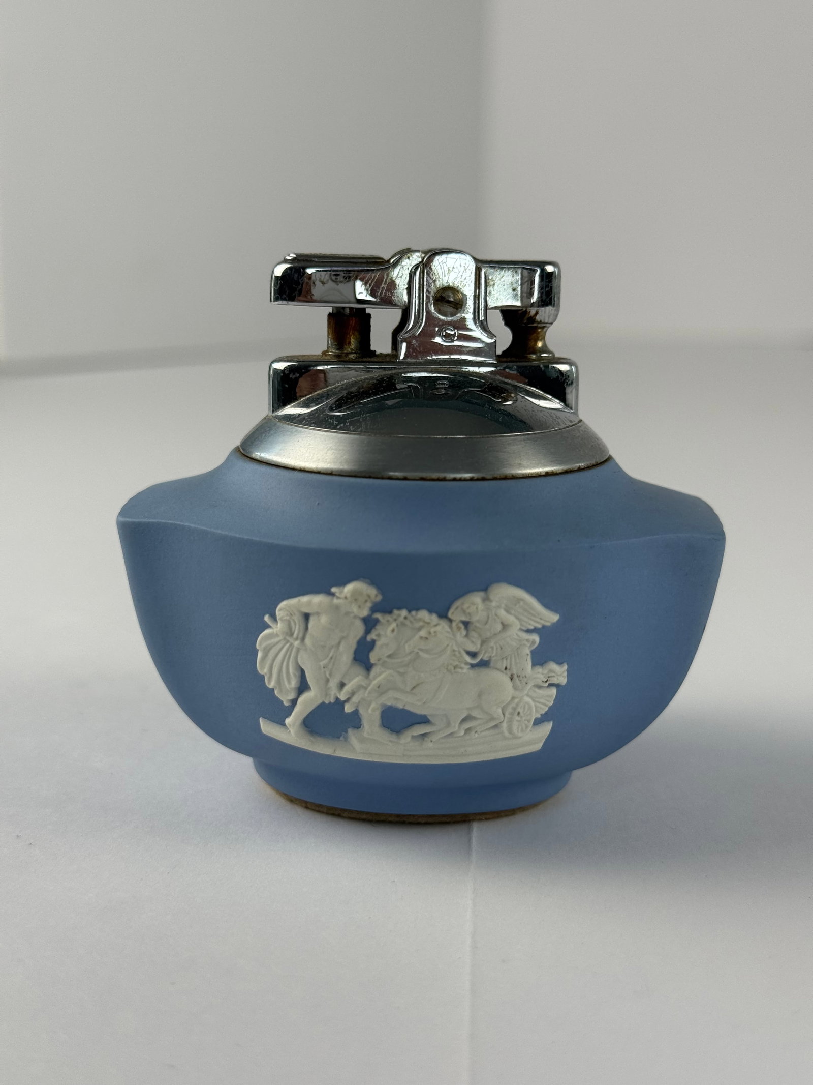 Wedgwood Blue Jasperware Table Lighter with Ronson Mechanism: A distinctive Wedgwood blue jasperware table lighter, fitted with a Ronson lighter mechanism and marked “Wedgwood, Made in England” to the underside. The ceramic body features the classic matt