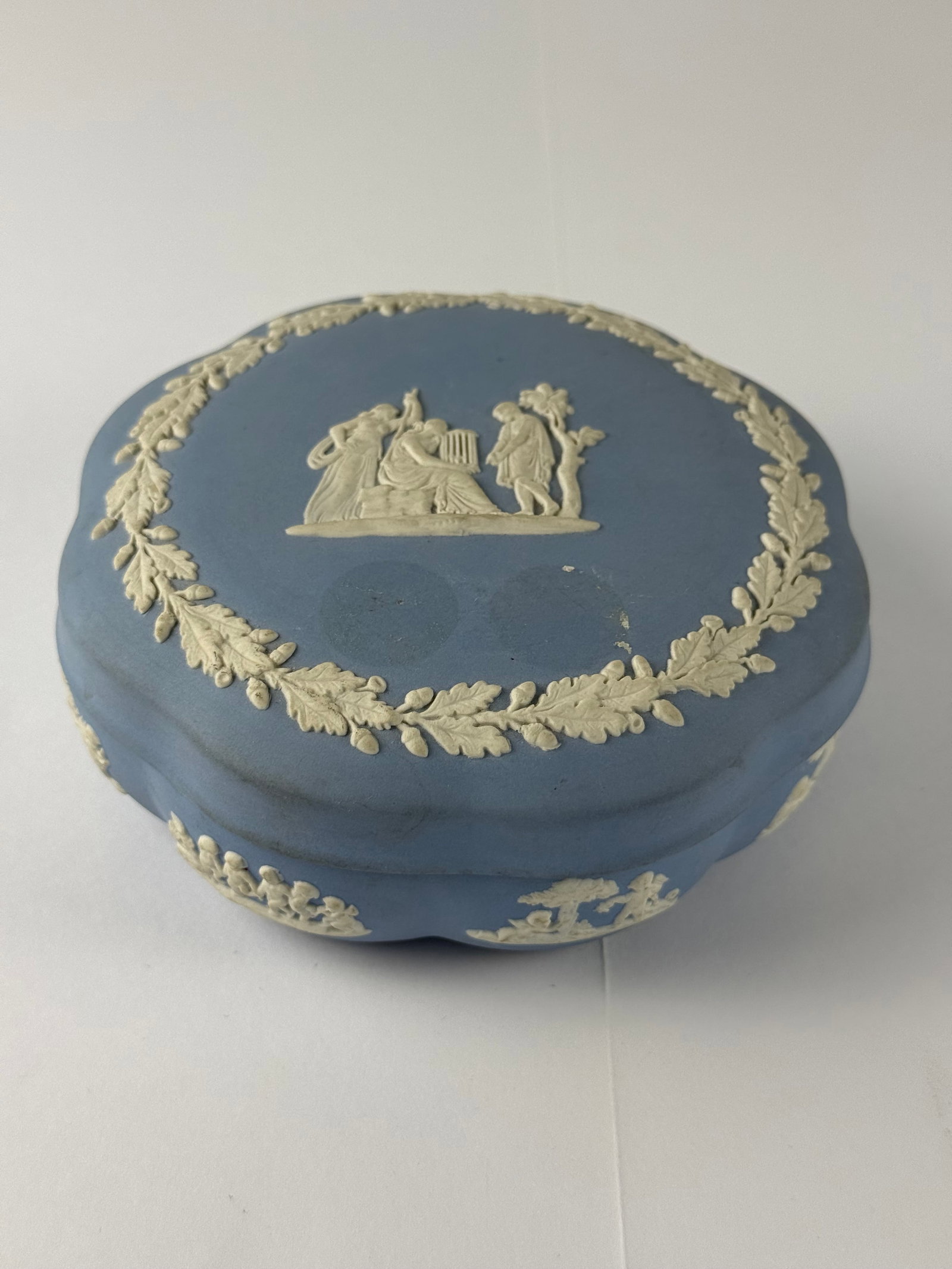 Wedgwood Jasperware Lidded Jewelry Box: An authentic Wedgwood jasperware lidded trinket or jewelry box, executed in the classic matte blue ground with applied white relief decoration. The lid features a finely detailed Neoclassical scene of