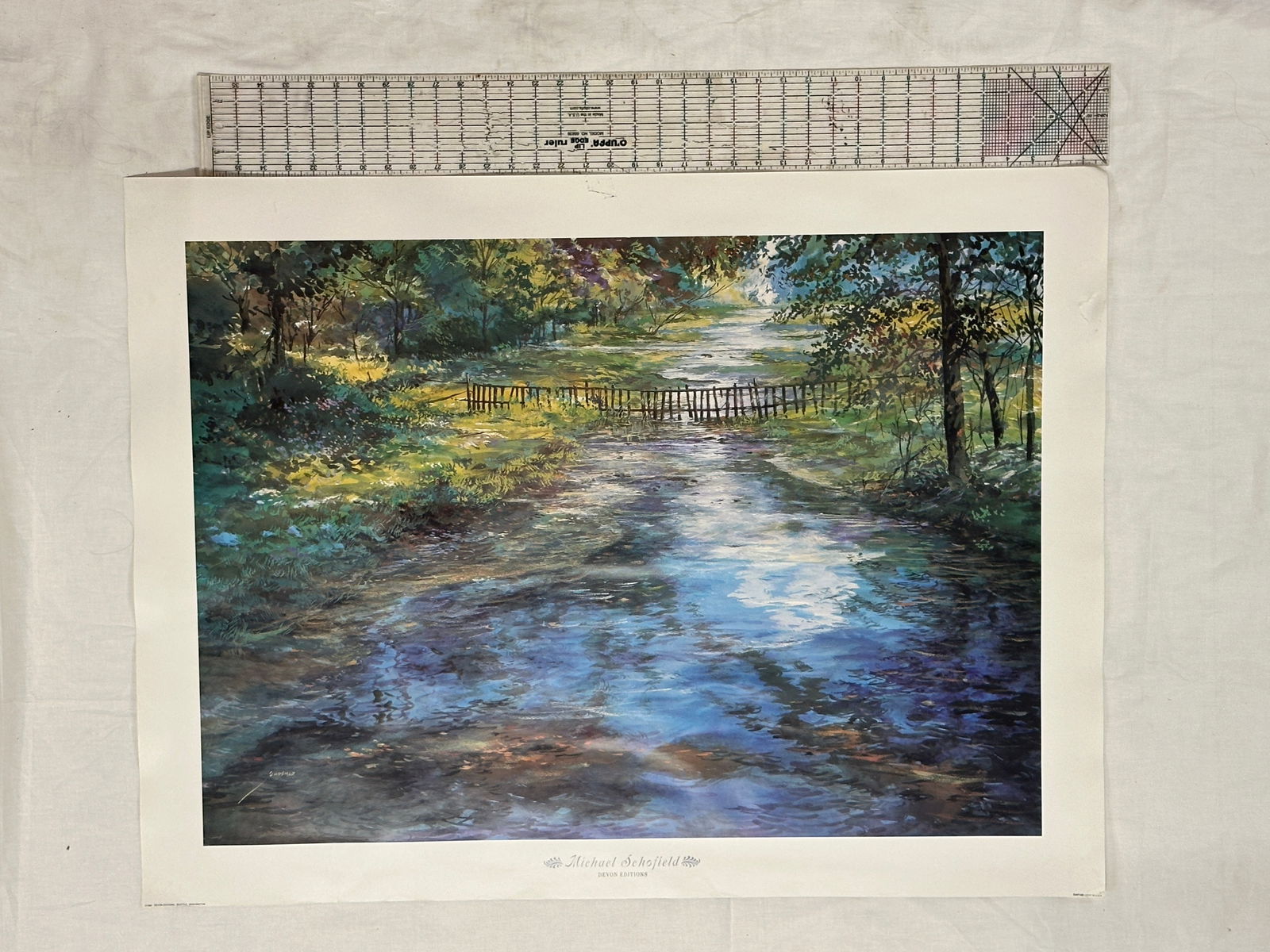 Michael Schofield Devon Editions Print: This is a limited edition print by artist Michael Schofield, depicting a serene landscape with a stream and a wooden bridge. The artwork showcases Schofield's signature impressionistic style, characte