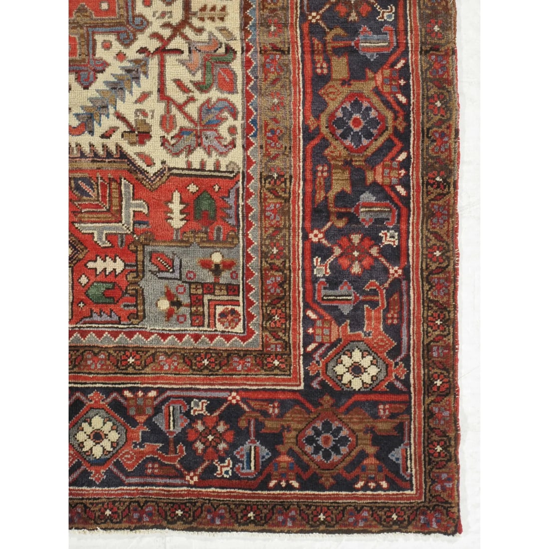 Vintage Persian Heriz Rug 8'3" X 11'5": Vintage hand-knotted Persian Heriz wool rug with a red field centered by a large geometric medallion in navy, ivory, and rust tones, with angular corner spandrels and a multi-band border. Heriz rugs a