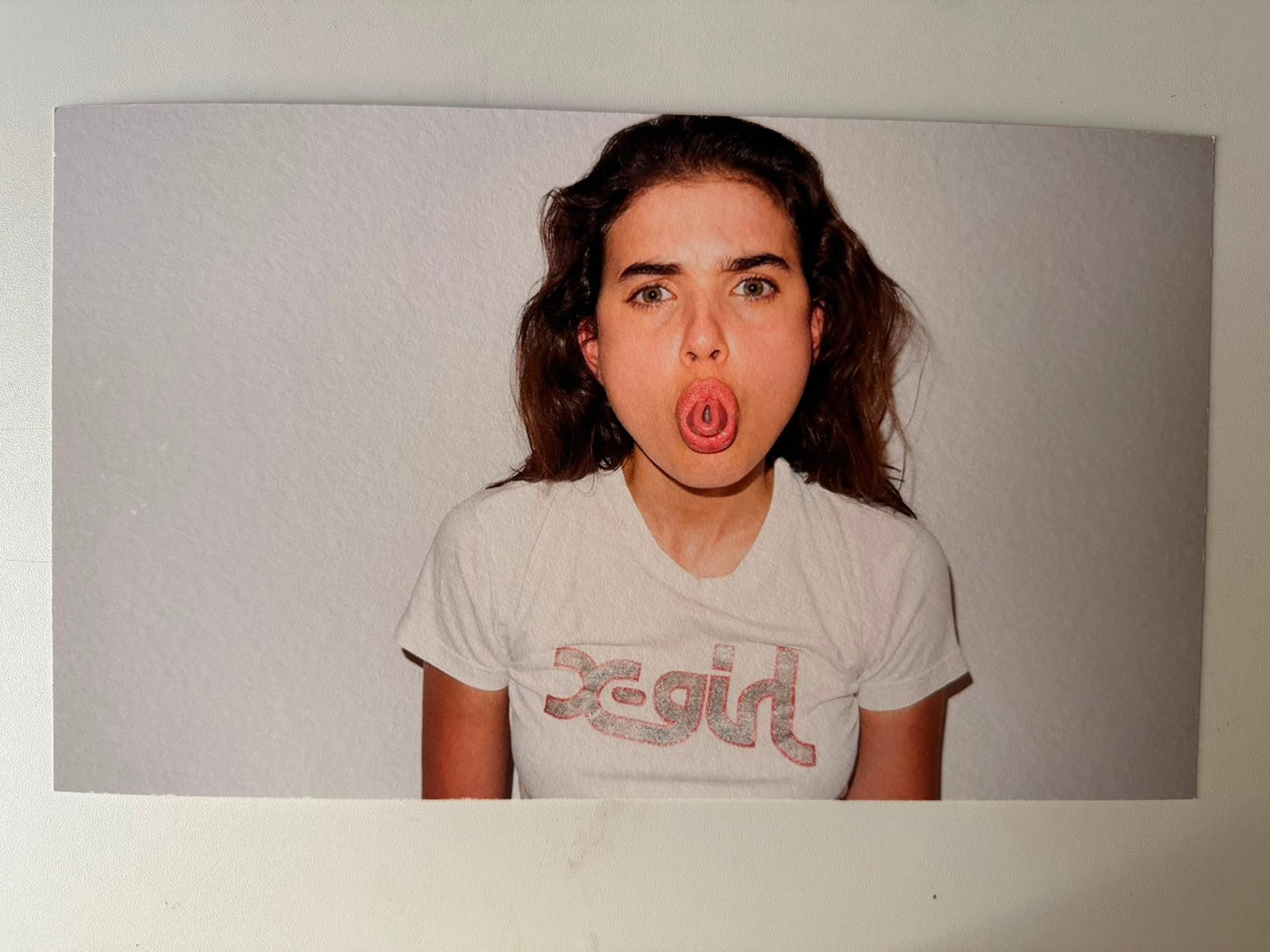Terry Richardson – Girl in X-Girl T-Shirt (Tongue Trick) | Original Fine Art Print (32x19 cm) –: Terry Richardson (b. 1965)Portrait of Model in "X-Girl" Tee Performing Tongue TrickMedium: Fine Art Print on Heavy Coated Satin/Textured PaperDimensions: 32 x 19 cm (approx. 12.6 x 7.5 inches)Signatur