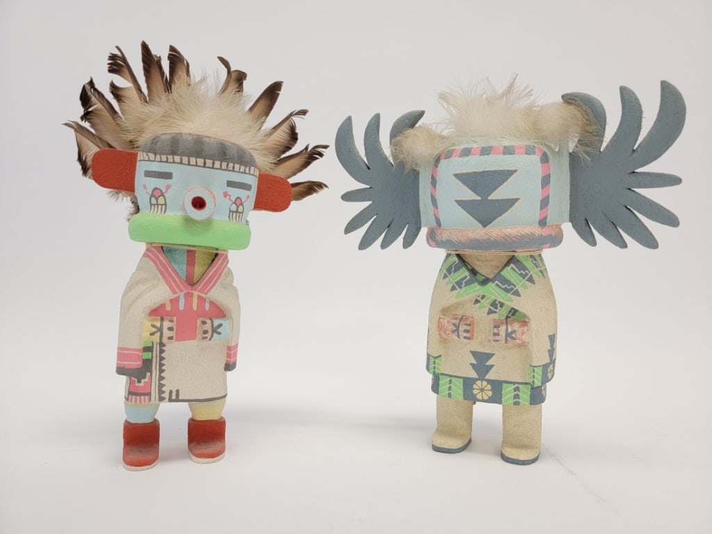 2 CHESTER POLEYESTEWA CARVED WOOD KACHINA DOLLS: Two carved wood Hopi kachina dolls by Chester Poleyestewa. Includes "Morning Singer" (13" tall to top of feathers, or 9.5" to top of wood), and "Crow Mother" (10.5" tall). Both pieces are signed on fo