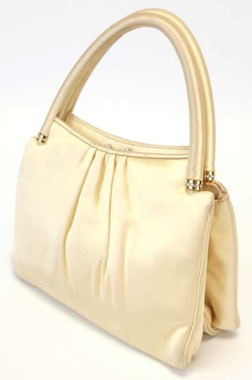 JUDITH LEIBER PALE YELLOW SATIN EVENING BAG: JUDITH LEIBER PALE YELLOW SATIN EVENING BAG: top handle satin evening bag with gold tone hardware and Swarovski encrusted acorn kiss-clasp, mounts at bottom of handles and gold tone chain strap. Inter