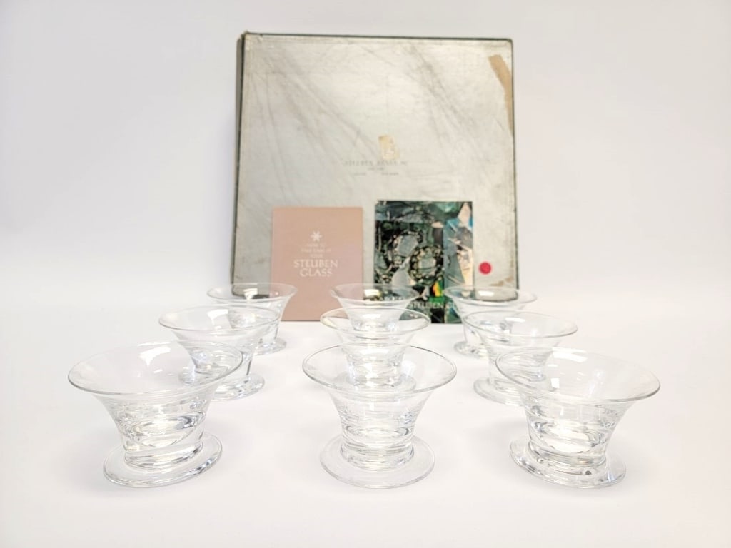 BOXED SET 9 STEUBEN GLASS SEAFOOD COCKTAIL BOWLS: Boxed set of nine Steuben glass seafood cocktail bowls or glasses. Each one measures 2-5/8" tall x 4-1/4" diameter, and is signed "S" on base. Lot includes original box and dust bags. Condition: box s