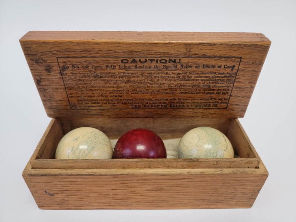 BRUNSWICK-BALKE-COLLENDER CO BILLIARDS POOL BALLS: Brunswick-Balke-Collender Co set of three boxed billiards or pool balls. Includes two white and one red, with original box. Box measures 3.25" tall x 8.5" x 3.5" deep. Condition: normal signs of age,