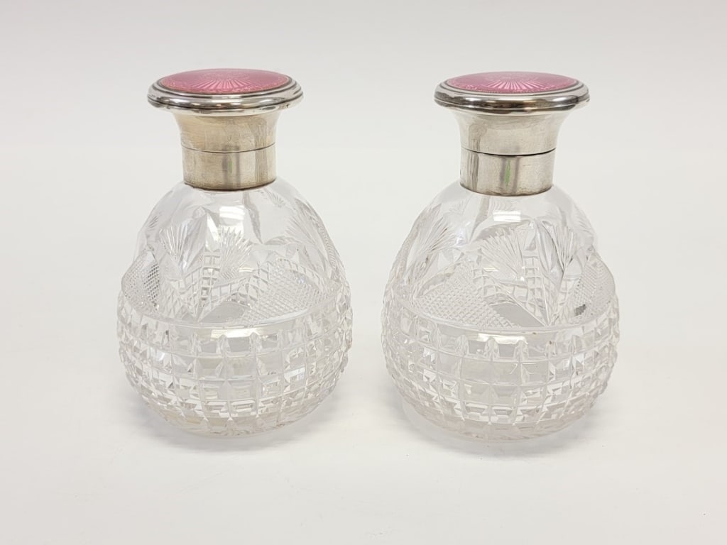 PR CUT CRYSTAL, STERLING & GUILLOCHE COLOGNE BOTTL: Lot of two antique cut crystal, sterling silver, and pink guilloche enameled cologne bottles by Mappin & Webb. Both bottles are hallmarked appropriately on the sterling neck. Height: 5" tall x 3.5" wi