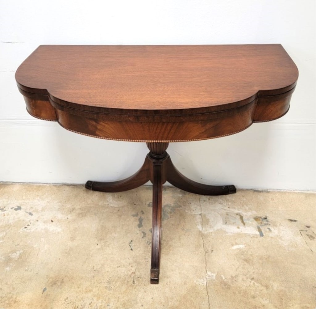 VINTAGE MAHOGANY FLIP TOP PEDESTAL GAME TABLE: Vintage mahogany flip top pedestal game table, Duncan Phyfe style tripod base with brass feet. Flame veneer front apron with a beaded trim. Measures a total of 34.1" wide and 29.25" tall and 17.25" de