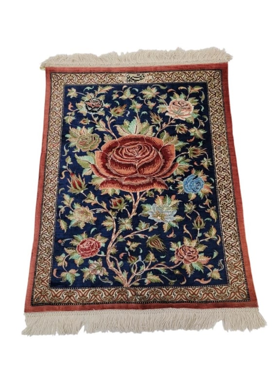 SMALL TURKISH HEREKE HAND KNOTTED SILK RUG: Small Turkish Hereke hand knotted silk rug measuring 28" x 22.25". Has a stitched on strip of leather for the hanging pole to pass through. Signed one one end near fringe. Condition is very good with
