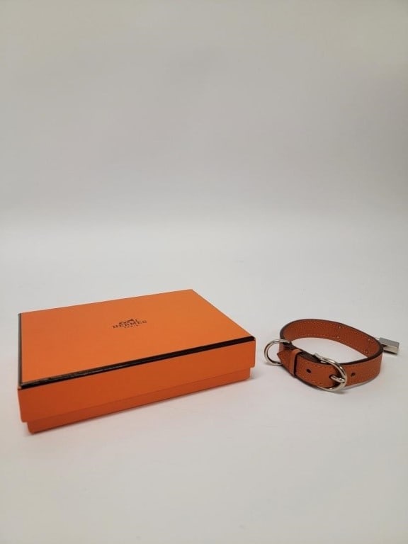 HERMES "KELLY" ORANGE LEATHER DOG COLLAR: Hermes "Kelly" orange Taurillon Clemence leather dog collar for a small dog. Unbuckled and laid out, it measures 11.25" long. Includes Hermes ribbon and orange box. Condition: box may show minor signs