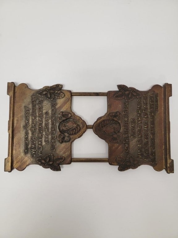 ANTIQUE "SONG OF HIAWATHA" ADJUSTABLE BOOKEND: Antique "Song of Hiawatha" cast metal adjustable bookend. Fully collapsed, it measures 12.75" long x 7" x .75" thick. Upright it measures 6" tall x 12.75" long. Condition: normal signs of age and