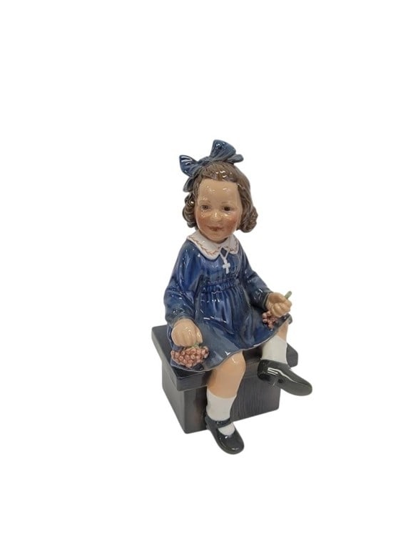 DAHL JENSEN PORCELAIN FIGURINE, "ELSE" #1207: Dahl Jensen porcelain figurine, titled "Else", number 1207. Subject: seated girl with berries or grapes. Measures 7.45" tall x 3.75" wide. Marked accordingly on base. Condition: good, no signs of dama