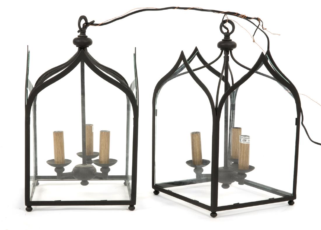 PAIR OF IRON AND GLASS LANTERN FIXTURES: Modern fixtures with a Gothic arch, each with three lights. 18 by 10 by 10 inches Categories: Tommy Hilfiger
