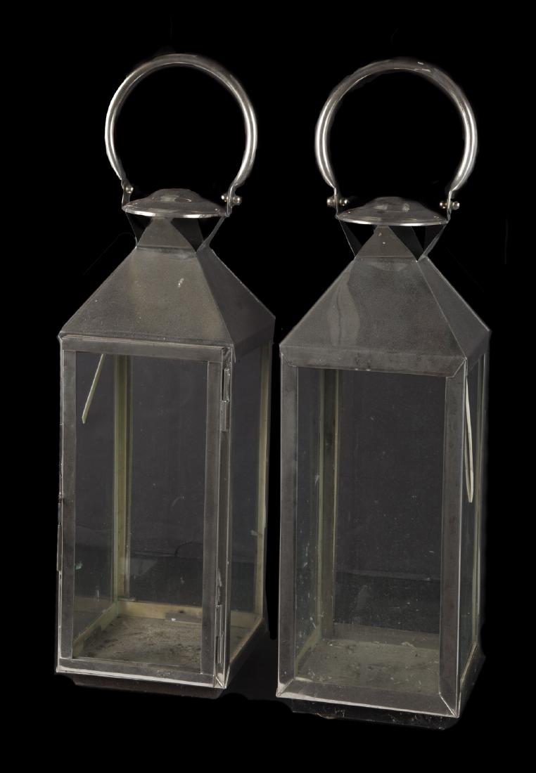 PAIR OF CHROME LANTERNS: Modern lanterns with glass panels. 26 1/2 by 7 1/2 by 7 1/2 inches Categories: Tommy Hilfiger