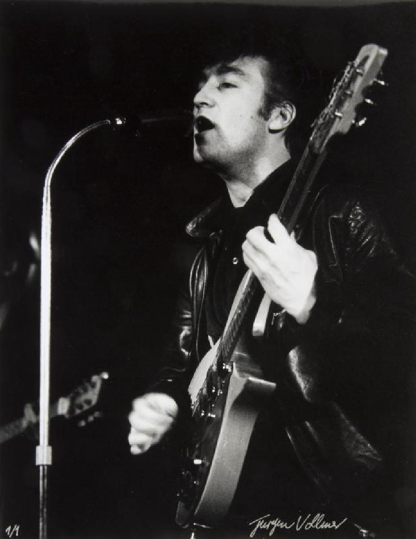 JOHN LENNON PHOTOGRAPH BY JÜRGEN VOLLMER, 1961: A black and white photograph of John Lennon performing at the Top Ten Club in Hamburg, Germany, in 1961 taken by Jürgen Vollmer and printed by Vollmer from the original negative. The photograph is si