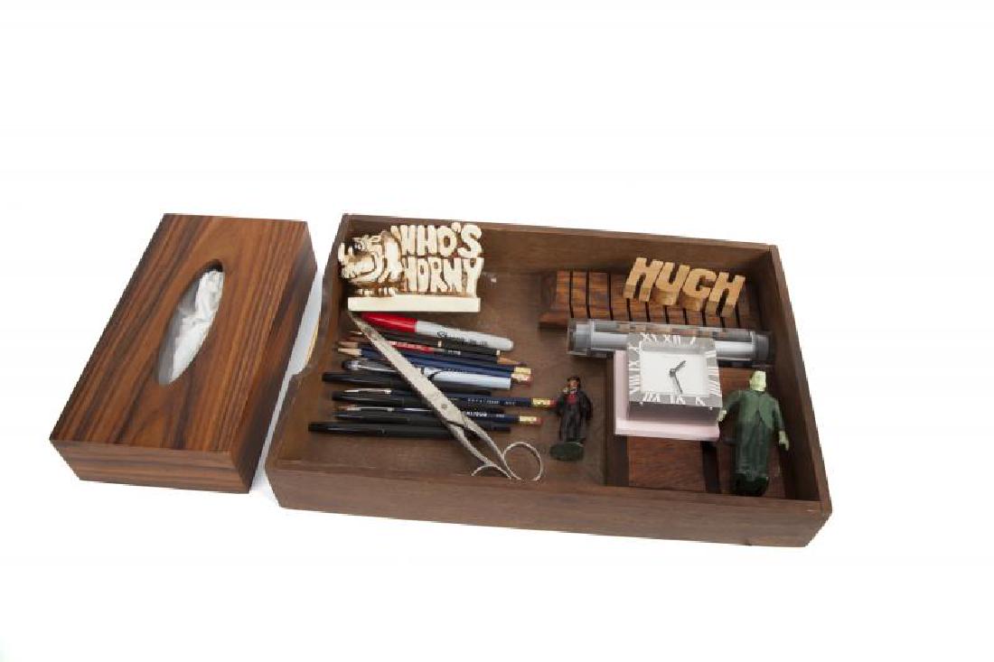 HUGH HEFNER DECORATIVE OBJECTS: A group of objects including a Tiffany & Co. battery-operated clock, another silver colored desk clock, a Sherlock Holmes lead figurine, a novelty rhinoceros object, a carved wood block reading ""Hugh