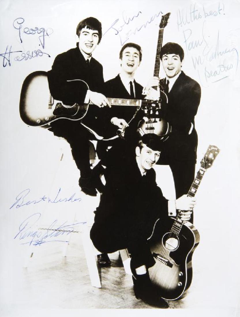 THE BEATLES SIGNED PHOTOGRAPH: A black and white promotional photograph signed by George Harrison, John Lennon, Paul McCartney, and Ringo Starr. McCartney has additionally inscribed "All the best!" and "(Beatles)" and Starr has ins