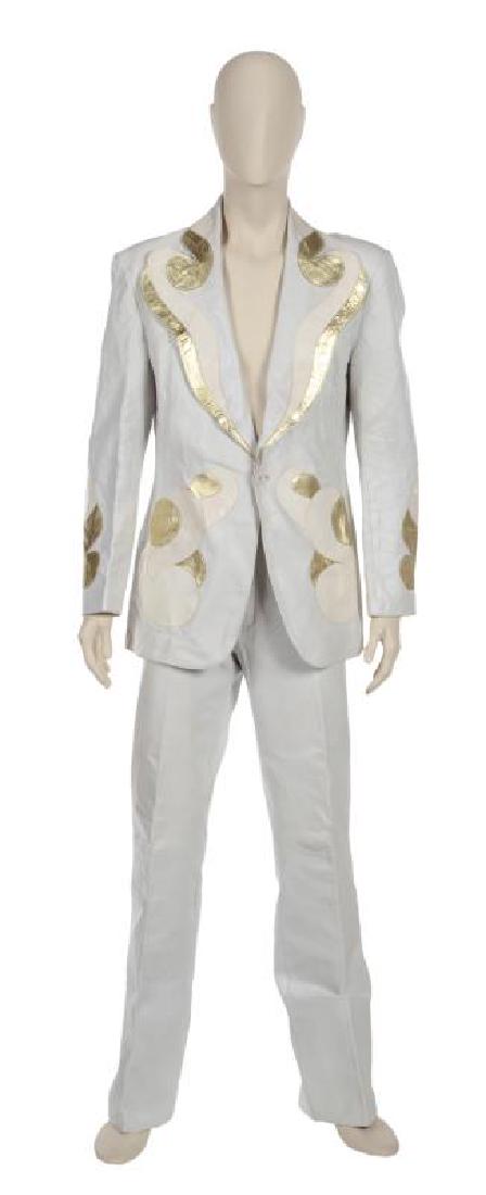 GREG LAKE STAGE WORN LEATHER SUIT •: A white leather Maxfield Parrish suit, worn extensively on stage throughout the 1970s by Greg Lake. The single-breasted jacket has applied metallic gold leather and white lizard skin embellishment in