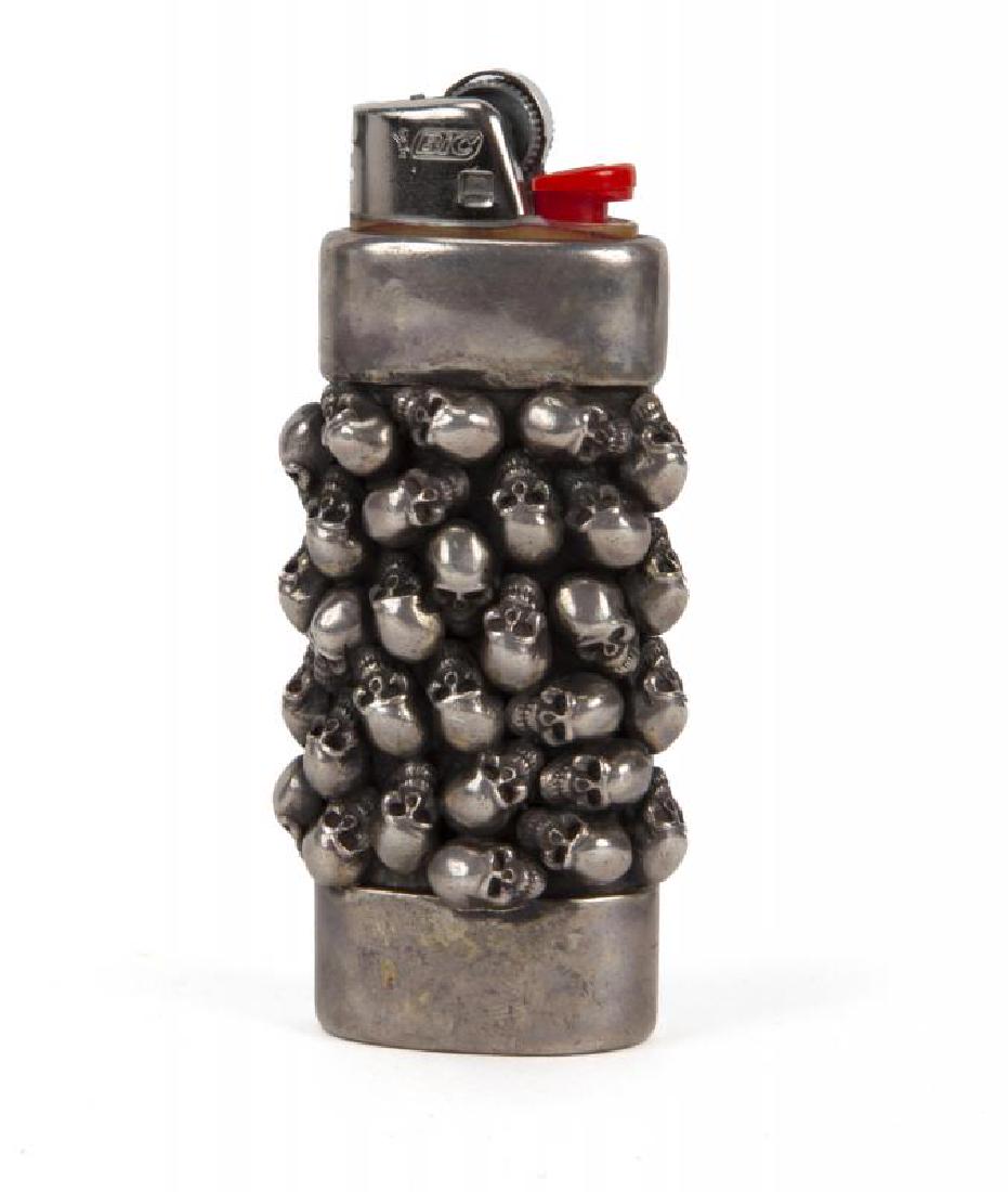 SLASH STANLEY GUESS SKULL LIGHTER COVER: A sterling silver skull Bic lighter cover marked "Stanley Guess 2000/ 925" and signed "Stanley" on the underside. Gross weight, 5.05 troy oz. Height, 2 3/4 inches PROVENANCE From the Collection of Sla