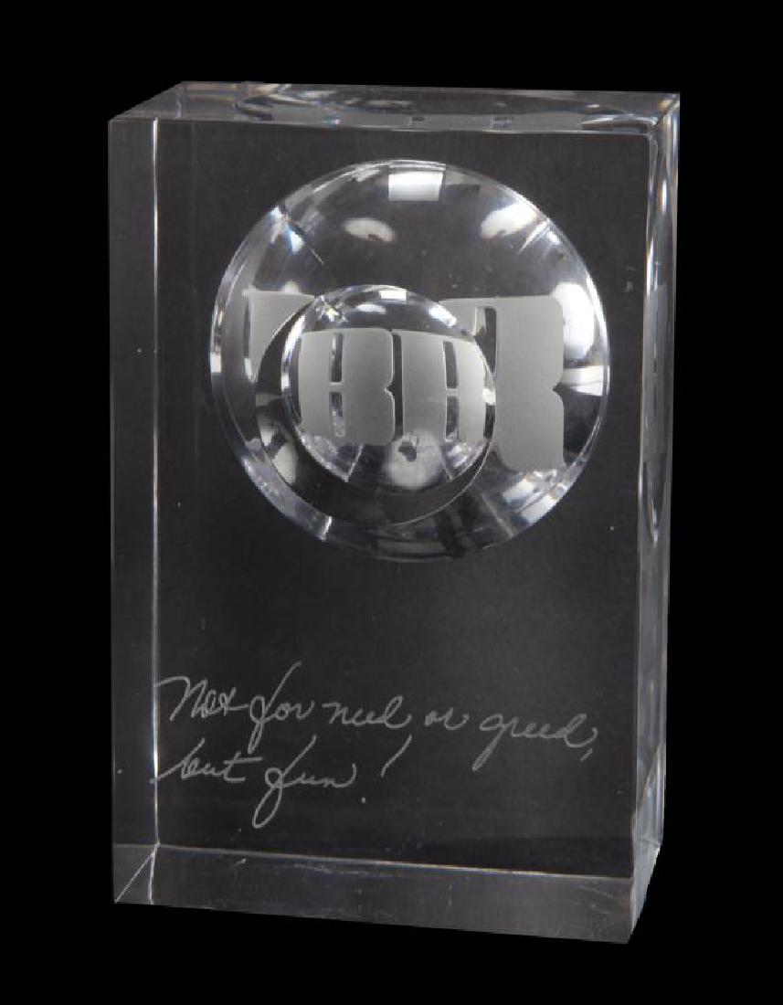 BURT REYNOLDS MONOGRAMMED CRYSTAL SCULPTURE: A single rectangular glass slab with BR monogram etched within a convex recess, also etched to the front face with a quote, "Not for need or greed, but fun." Marked to the underside with "Orrefors Exp