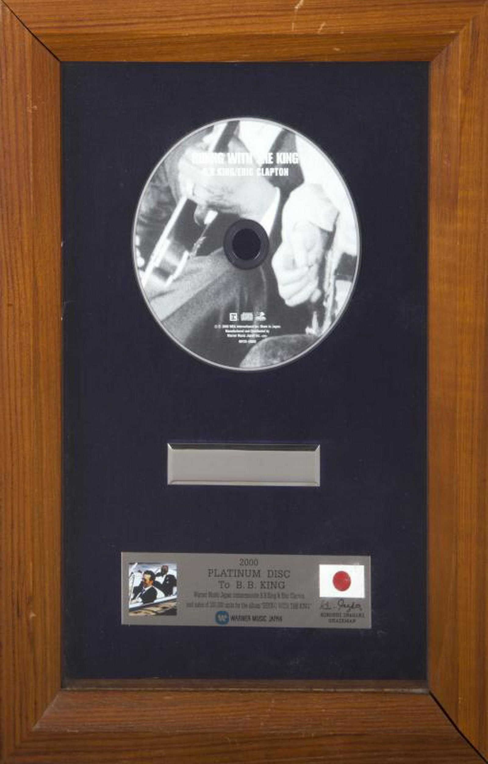 B.B. KING PLATINUM RECORD AWARD FOR RIDING WITH THE: A "platinum" disc award, dated 2000, presented to B.B. King by Warner Music Japan to commemorate B.B. King and Eric Clapton for the sale of 300,000 units of the album Riding with the King. 14 by 10 in
