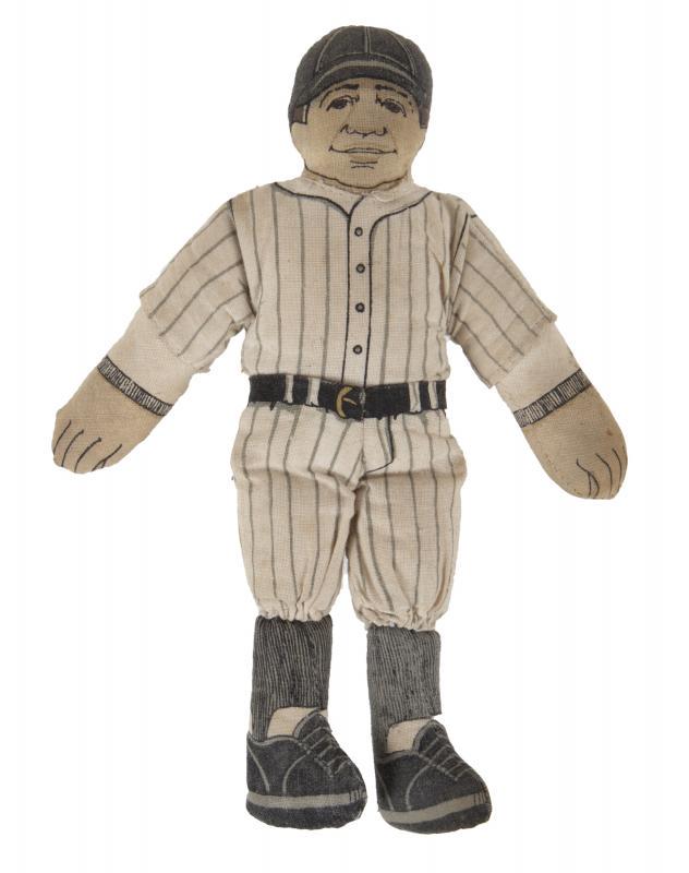 BABE RUTH DOLL IN UNIFORM: A 1930s Babe Ruth doll wearing the famed New York Yankees jersey with the number 3 on the back. The doll features composition head, hands, and shoes, while the doll itself is put together with regular