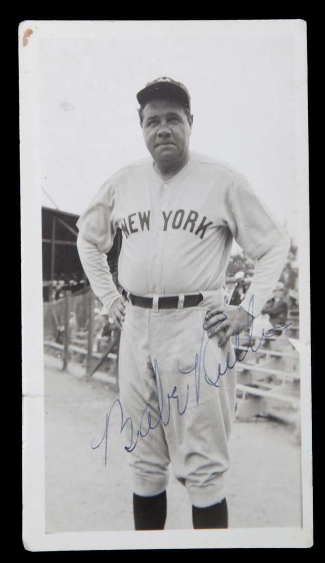 BABE RUTH SIGNED PHOTOGRAPH: An original black and white photograph signed by Babe Ruth to the lower margin in blue ink. Ruth is pictured wearing a New York Yankees road uniform. Inscribed on verso "Babe Ruth Yankee" in black ink
