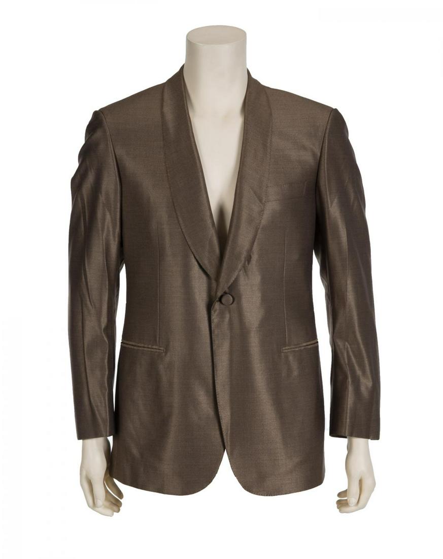 ERIC CLAPTON SIGNED BRIONI JACKET: A brown lamé suit jacket signed by Eric Clapton in silver marker on the interior. The jacket bears a Brioni label, size 50. Accompanied by a Brioni garment bag. PROVENANCE From the Collection of Eric