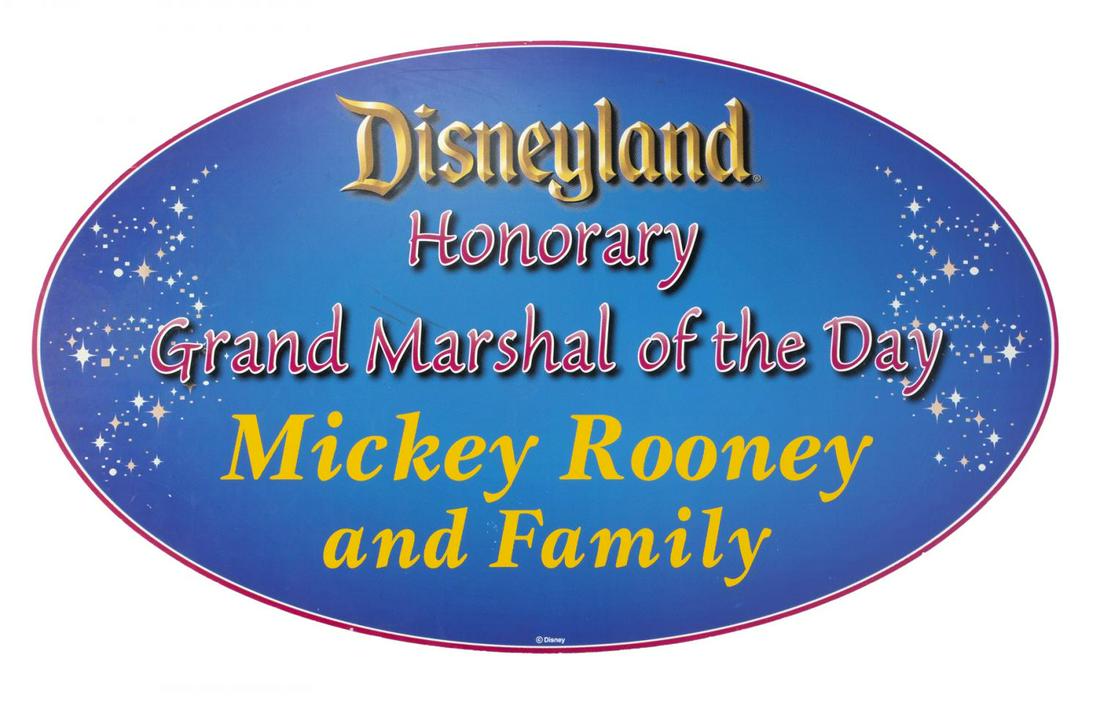 MICKEY ROONEY DISNEY-RELATED ITEMS: A group of four items: an oval sign reading “Disneyland/ Honorary/ Grand Marshal of the Day/ Mickey Rooney/ and Family”; two 1976 scripts from Pete’s Dragon; and one transmittal enve