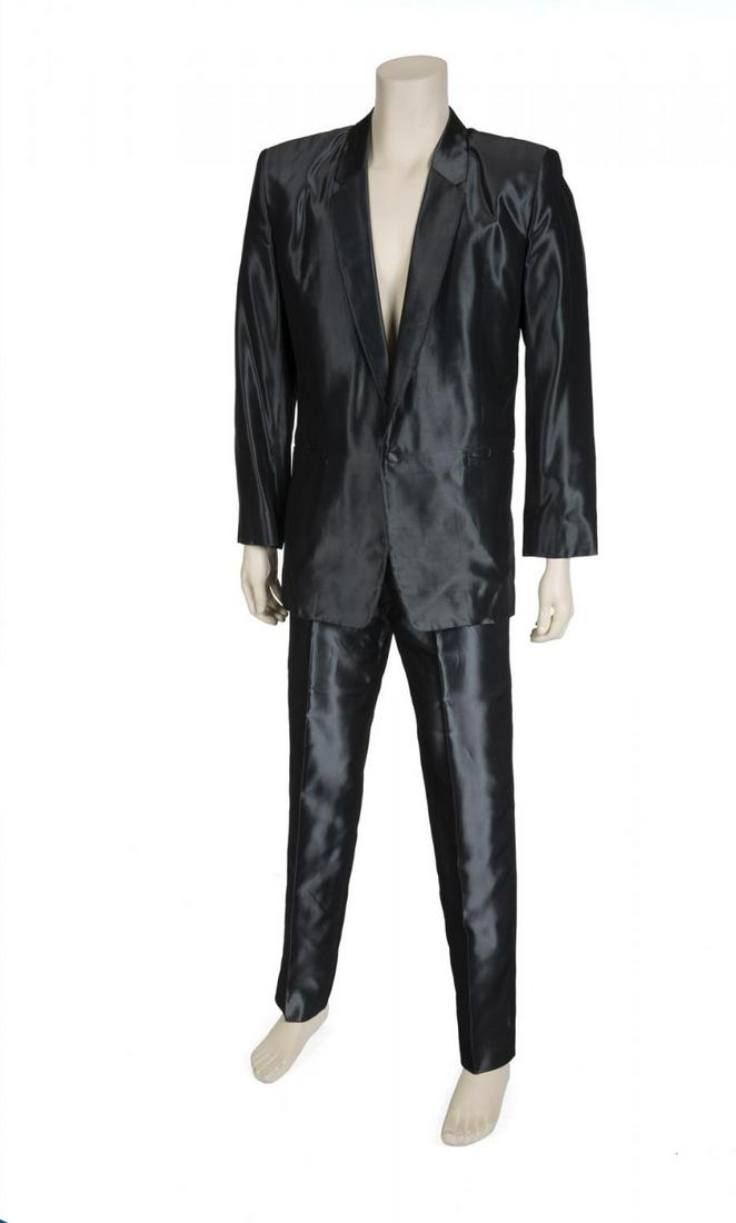 STEVE MARTIN SUIT RELATED TO MY BLUE HEAVEN: A two-piece ensemble consisting of a gunmetal gray silk single-breasted jacket with narrow notched lapels, two front welt pockets, lined in black silk, labels reading "Antony Price/ England" and "Size