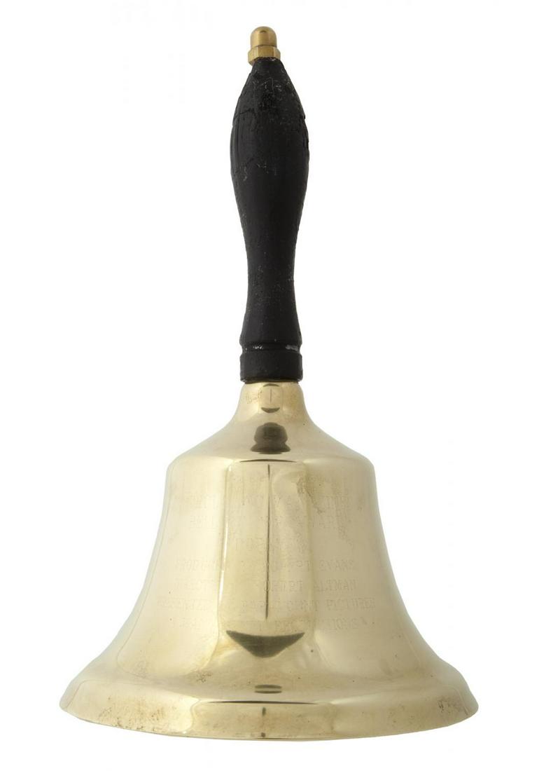 ROBERT EVANS 1980 AWARD RELATED TO POPEYE: A large brass bell with a black leather handle presented to Evans by Scholastic Magazines for producing the film starring Robin Williams and Shelley Duvall. 10 by 6 by 6 inches PROVENANCE From the Est