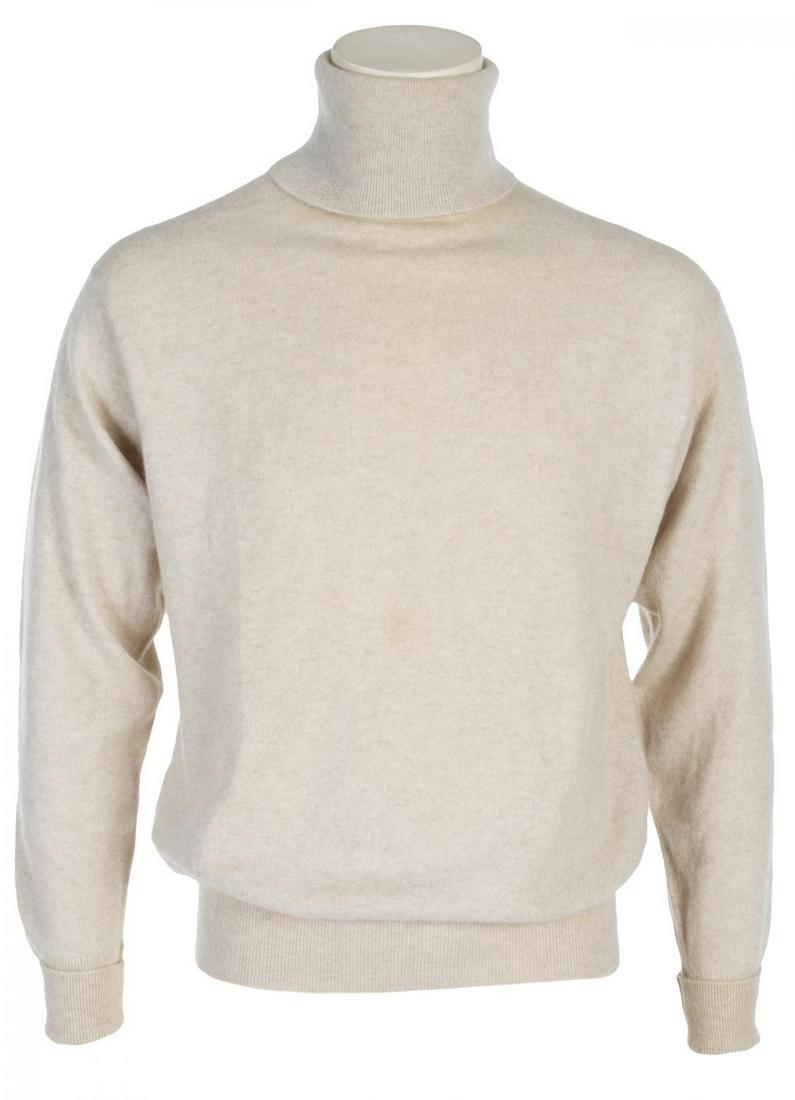 ROBERT EVANS TURTLENECK SWEATER: A bone colored William Locke cashmere turtleneck sweater (size 42). Many archival photographs feature Evans wearing this same or similar sweater as it was one of his signature looks. PROVENANCE From t