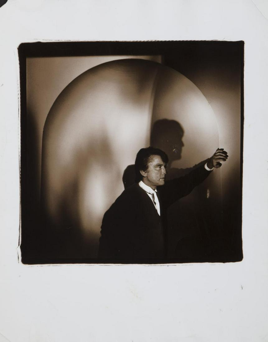 ROBERT EVANS PHOTOGRAPH BY MICHAEL GRECCO: A sepia tone profile portrait art photograph of Robert Evans, circa 1994. Marked on the verso in pencil "Robert Evans/ CR: Michael Grecco/Sygma 94-4140." 14 by 11 1/8 inches PROVENANCE From the Estate