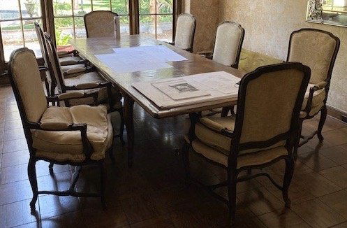 ROBERT EVANS DINING TABLE AND CHAIRS: An antique French oak parquet top dining table with cabriole legs and two expansion leaves, together with 10 Louis XV provincial style fauteuil dining chairs with padded arms, upholstered seats and ba