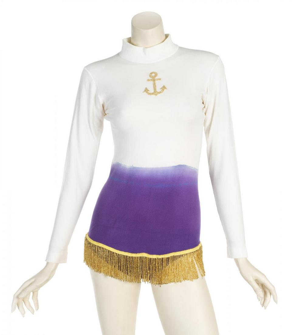ANN MILLER COSTUME LEOTARD AND PHOTOGRAPH: A white turtleneck with dyed skirt and gold seed bead fringe accents. Label reads “Brooks Van Horn, New York, Costumes” with “Ann Miller” written in pen. No size labels present