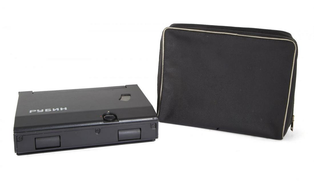 SOVIET KGB SPY RUBIN DOCUMENT COPIER: A Soviet KGB spy "Rubin" "roll over" or "brush" copying device for reproducing classified documents. Includes original bag and power plug and three additional film cassettes. Serial Number: N50921 6 1