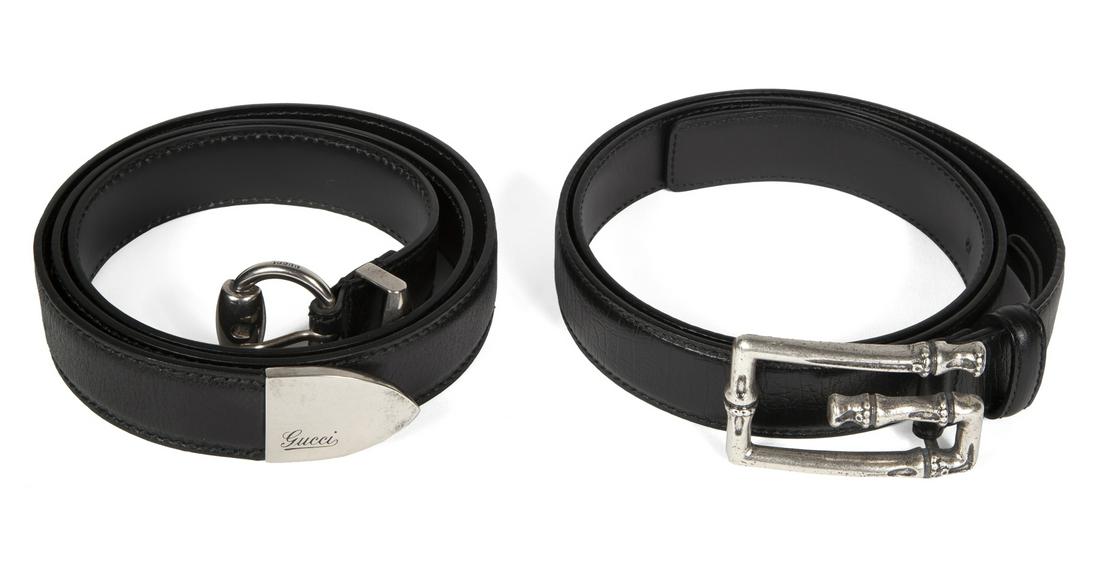 TWO BLACK LEATHER GUCCI BELTS: A black leather Gucci belt with silver tone western style hardware, size 40; together with a black leather Gucci belt with a skeletal G buckle, size 38. Fine Art