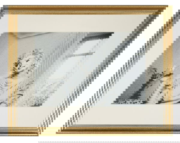 MARILYN MONROE PHOTOGRAPH: A black and white photograph depicting Marilyn with a wistful smile on her face as she holds a glass, shot by Ed Feingersh. Nicely matted and framed. 12 X 18 inches To order your fully illustrated Mar