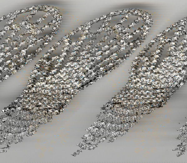 ANN MILLER PAIR ART DECO SHOE CLIPS: Art Deco style of simulated diamonds in silver metal, 3 ¾" long, circa 1970s. Very good condition, break in one section of rhinestone chain has been repaired.