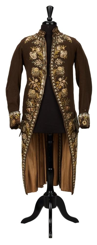 EMBROIDERED MEN'S COURT COAT: A men's waistcoat, circa late 18th century/early 19th century, featuring beautifully embroidered florals atop chocolate brown cotton, as well as a notched tail, large face buttons, and side pockets at