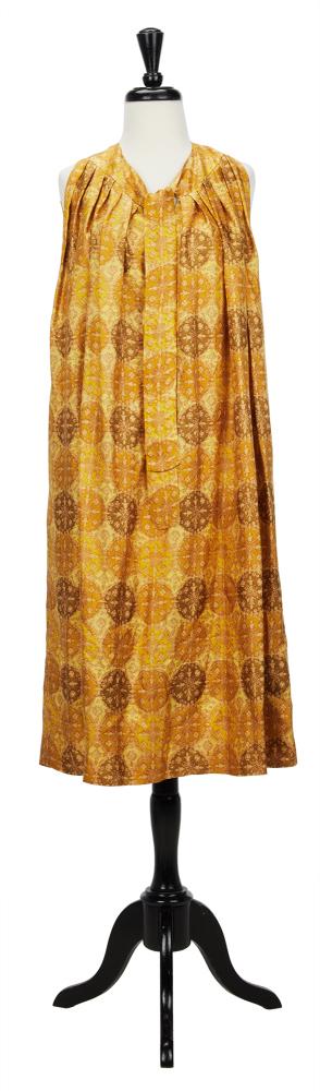 CLAIRE MCCARDELL: SLEEVELESS MEDALLION PRINT DRESS: A gold silk medallion print sleeveless dress with self tie at the neck and keyhole neckline. Pleated around the collar with pockets at the side. Labeled. Measurements (approximate): bust-40. Known for