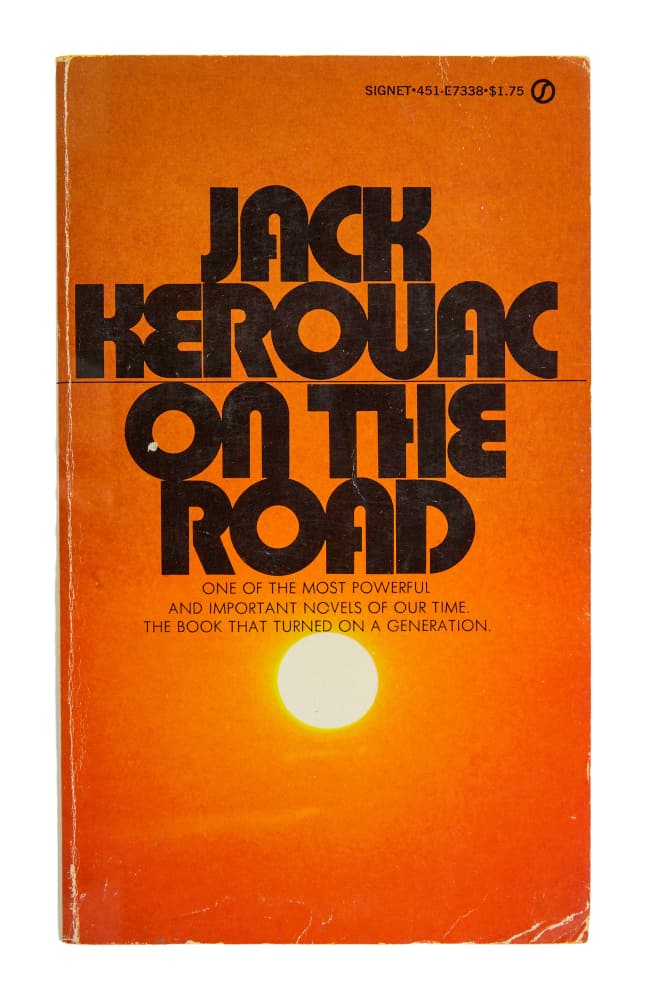 DENNIS HOPPER | PERSONALLY-OWNED "ON THE ROAD" PAPERBACK: A paperback copy of On The Road (Signet, circa 1980s) by Jack Kerouac that belonged to Dennis Hopper and was inscribed "Satya Loves You" in ink by Satya de la Manitou, Hopper's close friend and right-