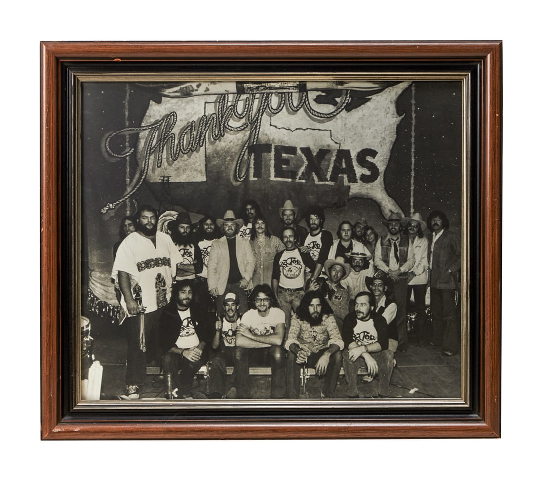 ZZ TOP | DUSTY HILL EARLY BAND PHOTO: A framed vintage photograph of the band, crew and management taken circa 1974, based upon the 1974 tour t-shirts that many of the crew members are wearing in the image. Dimensions: Overall: 24 by 27 3