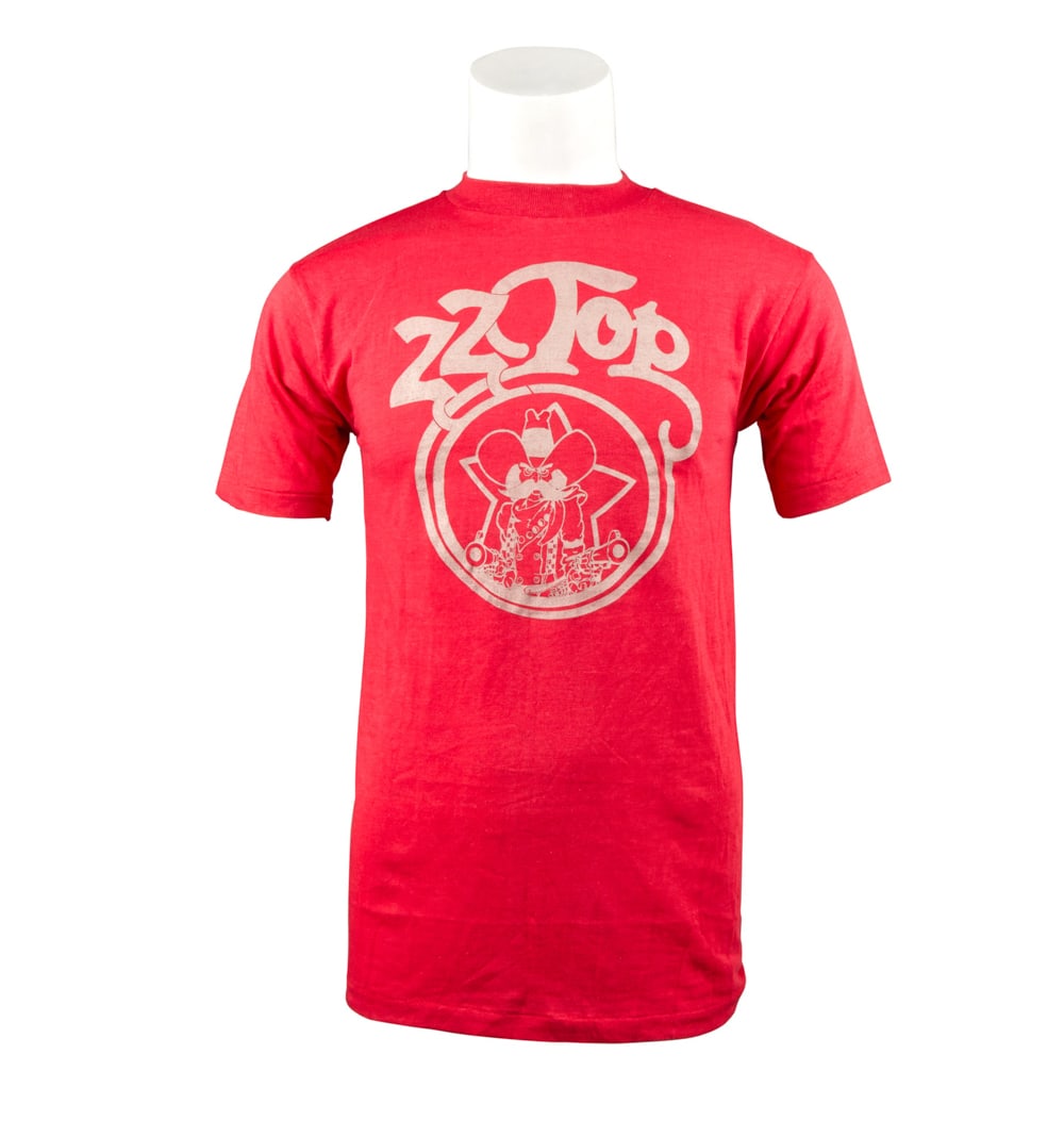ZZ TOP | DUSTY HILL 1975 TOURING SHIRT: A red cotton blend shirt with ZZ Top bandito graphic on front and "Touring / 1975" on back, size large. PROVENANCE From The Estate of Dusty Hill