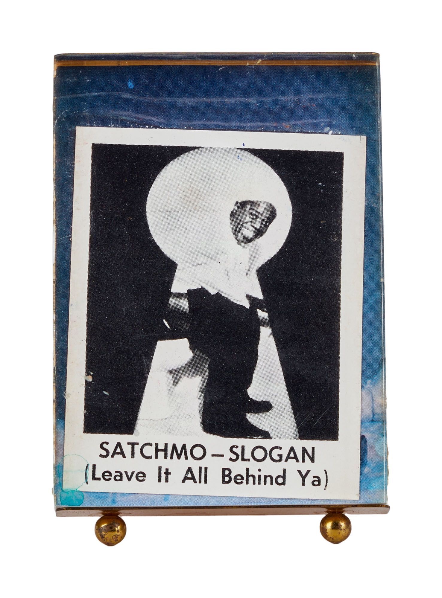 Tony Bennett | Louis Armstrong "Satchmo" Laxative Card: A card featuring an image of Louis Armstrong aka Satchmo that was used a series of advertisements for the laxative brand Swiss Kriss. The image on the card features Armstrong seen through a keyhole si