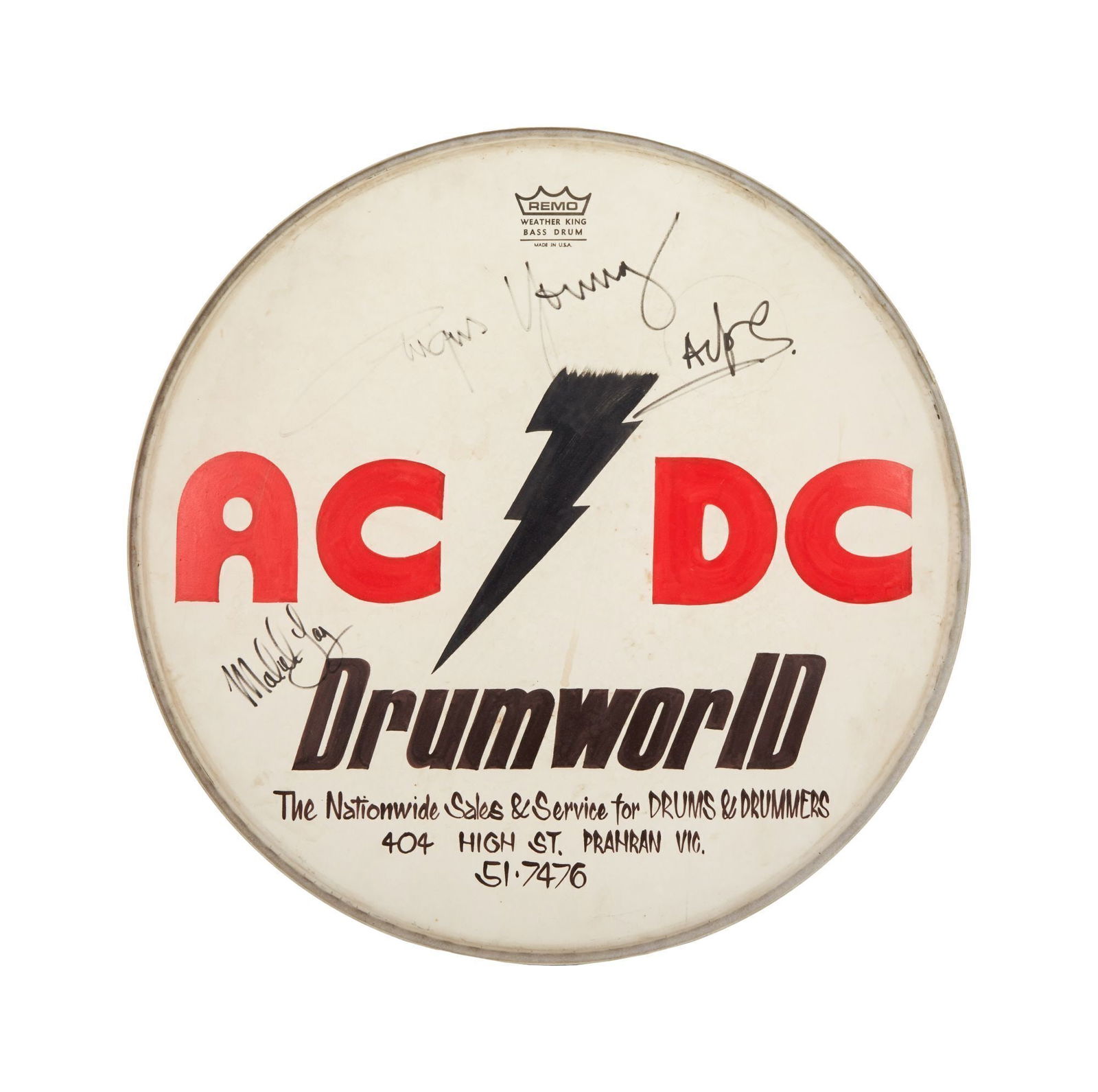 AC/DC | Early Phil Rudd Used Drumhead From The Bon Scott Era Signed By Angus Young and Malcolm Young: A Remo Weather King Bass Drumhead with early hand-painted "AC/DC" logo to the top in red and black, with additional black lettering below reading "Drumworld / The National Sales & Service for Drums &