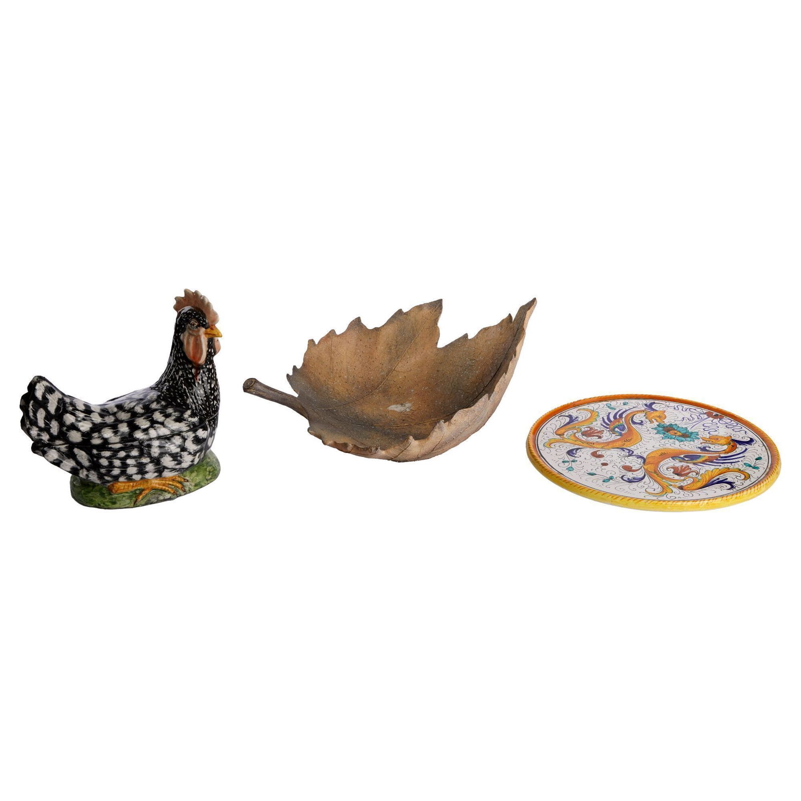 Christine McVie | Three Kitchenware Items: Including a painted ceramic rooster, a fired raku oak leaf bowl, and a painted Florentine trivet. Widest, 14 inches PROVENANCE: Property From The Life And Career of Christine McVie Decorative Arts Ple