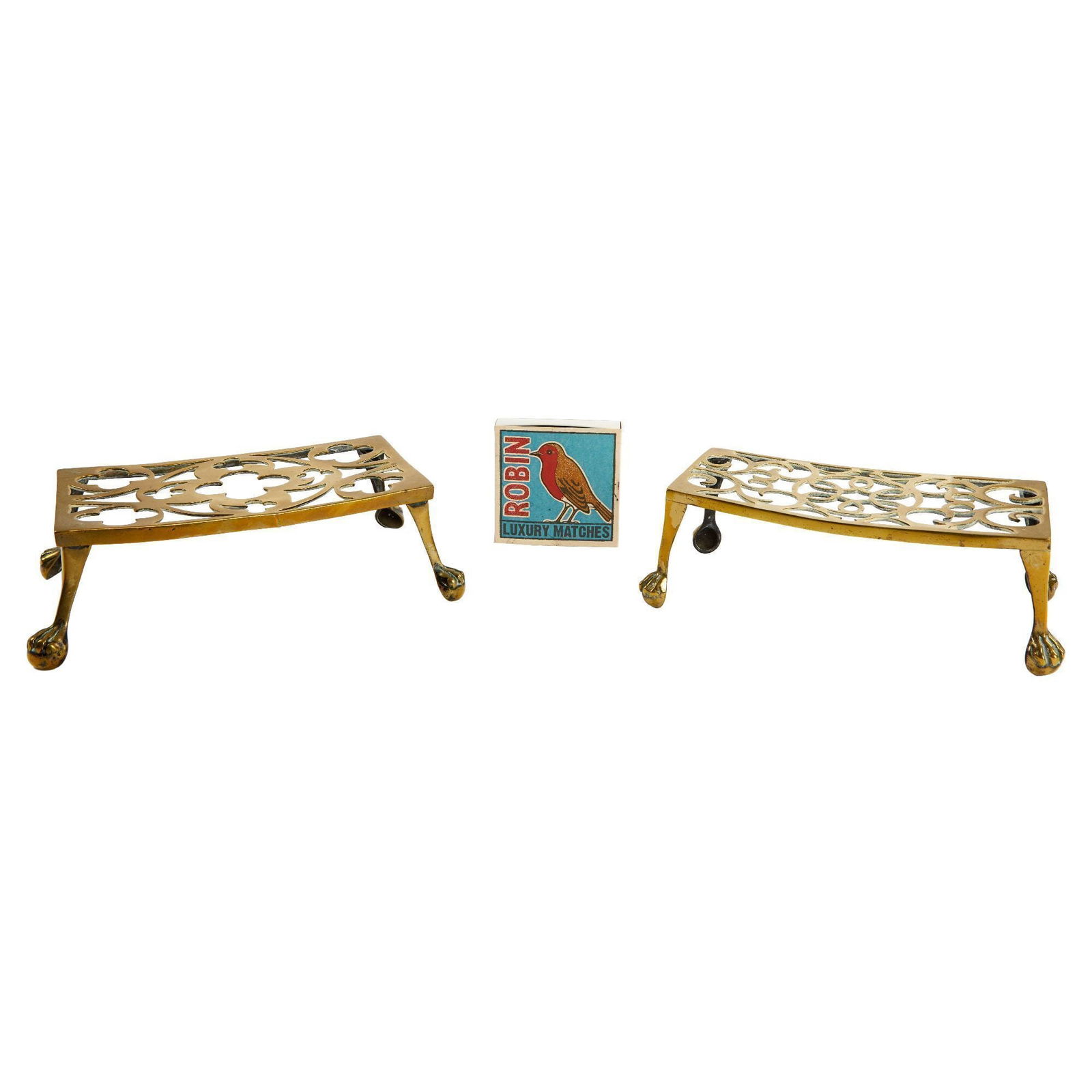Christine McVie | Pair of Victorian Fireplace Trivets and Robin Matchbox: A group of decorative fireplace implements, including filigree brass trivets and an empty box of Robin luxury matches. Trivets, 3.5 x 12 x 7.5 inches PROVENANCE: Property From The Life And Career of C