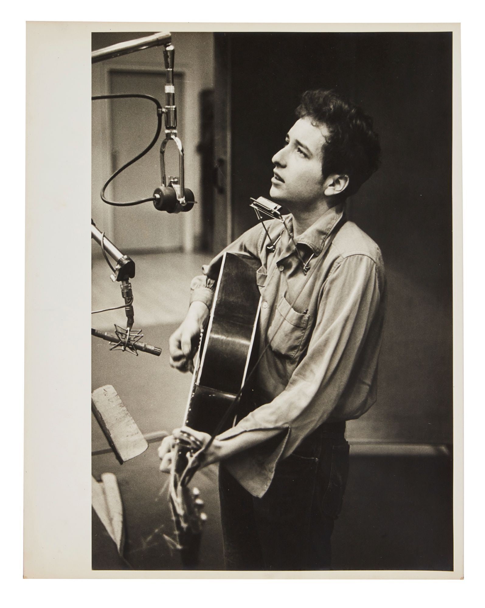 Bob Dylan | Large Vintage Photograph From 1961 Recording Session By Don Hunstein: A vintage 1960s photograph on archival paper of Bob Dylan in Columbia Records New York studio in November of 1961 recording his first eponymous album. Pencil notations on verso of image with a series